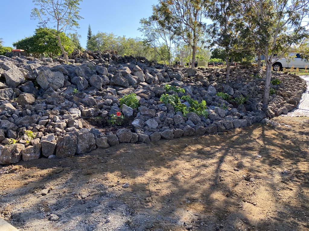 Kona landscaping company installing barrier wall during a hawaii landscape project.