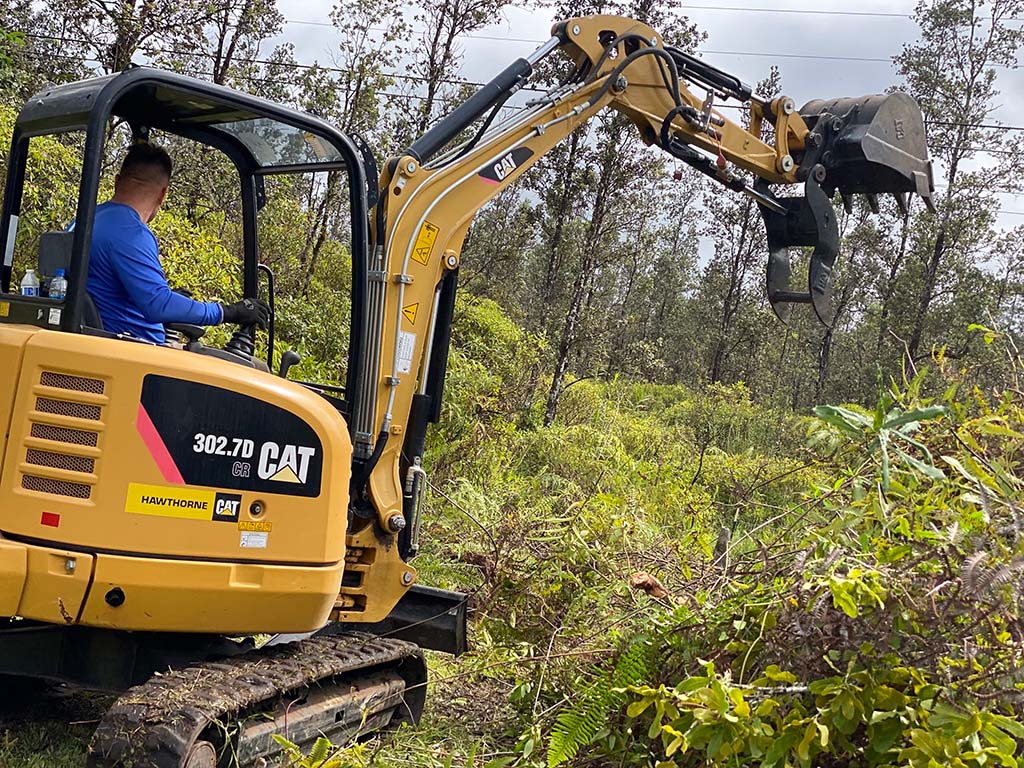 professional hawaii excavator operator removing brush as part of clean up services, Kailua-Kona.