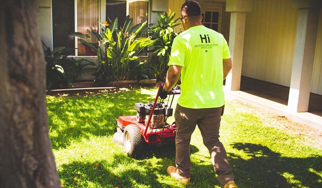 big island lawn mowing service being performed with a push mower in Kailua-Kona, Hawaii.