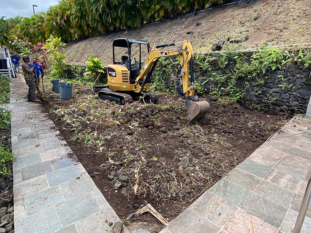 Lawn grading near Kailua-Kona. Hawaii Landscaping company level the ground with an excavator.