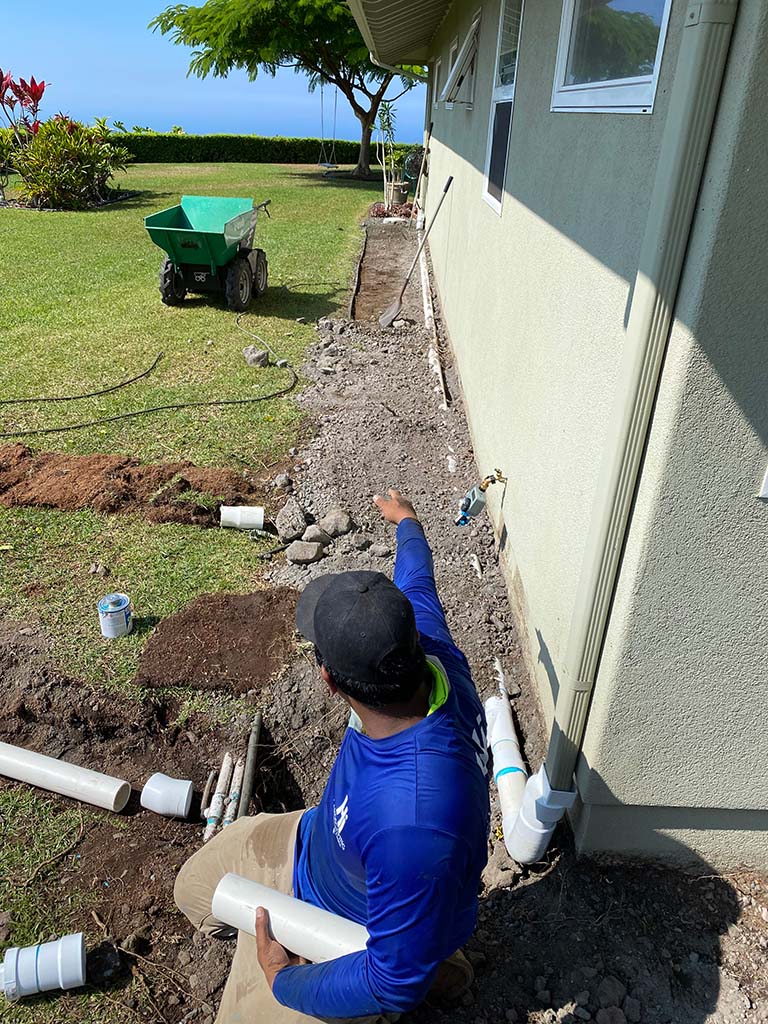Kona landscaper installing sprinklers, big island of Hawaii. Irrigation pipe installation as part of our Kailua-Kona landscaping services.