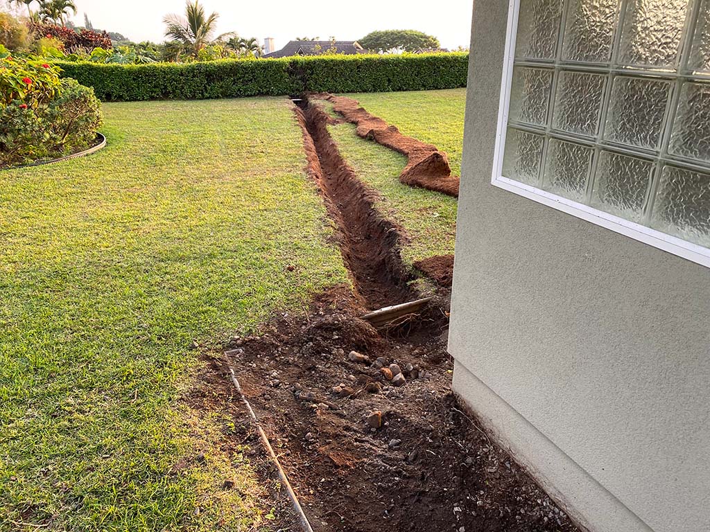 Dripline installation Kona, Hawaii. Landscape service includes trenching, flowerbed installation, and turf replacement.