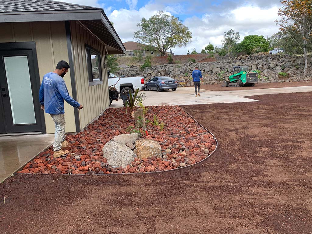 Big island landscapers install lava rock and decorative rock as part of a kona landscaping project. Fresh Hawaii topsoil installed in the yard.