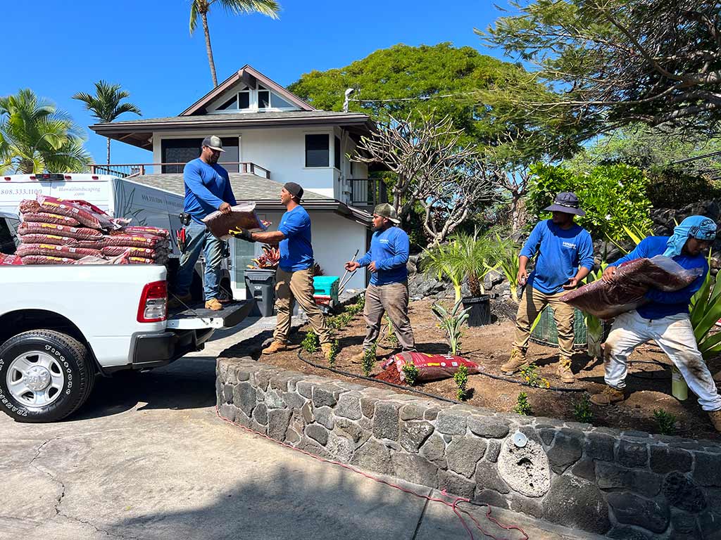 Hawaii Landscaping team unloads mulch to be used as ground cover for a planter.