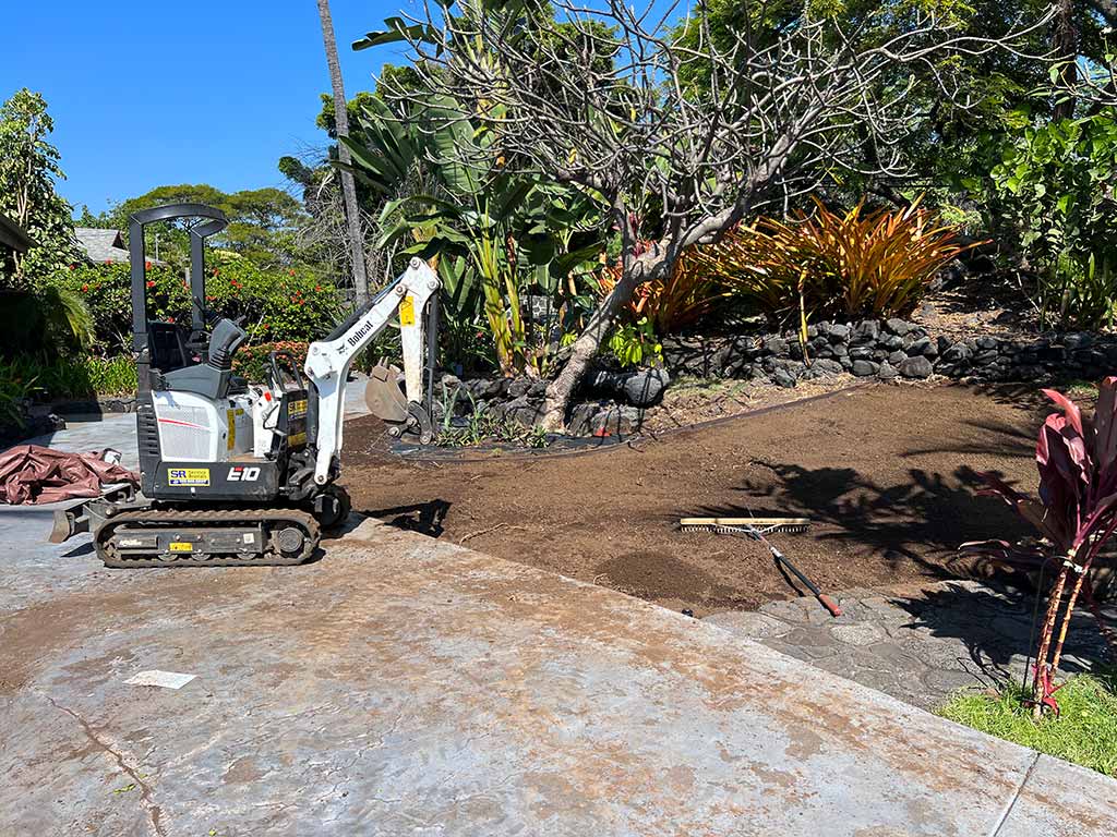 Excavator cleaning-up unwanted plants and debris, Kona.
