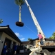 Hawaii crane operator moves a coconut tree into place during Kukio landscaping project.