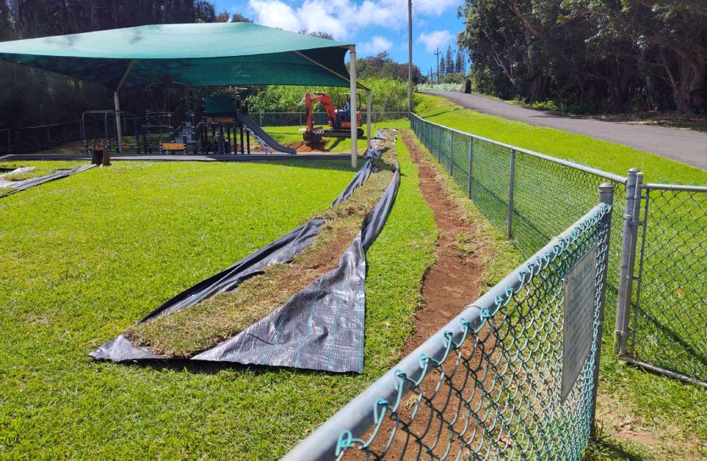 Excavator regrading slopes next to the play area.